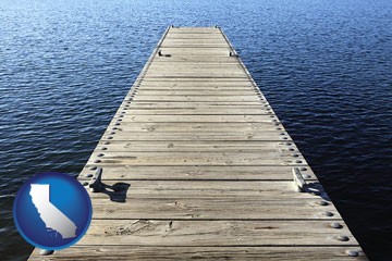 a boat dock on a blue water lake - with California icon