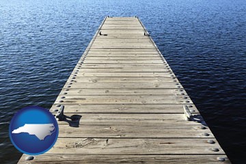 a boat dock on a blue water lake - with North Carolina icon