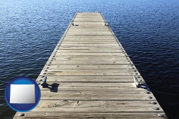 a boat dock on a blue water lake - with Wyoming icon